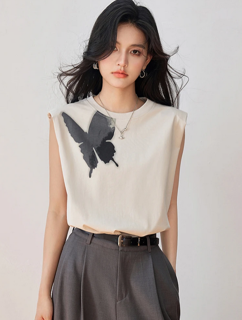 Woman wearing sleeveless cream top with large black butterfly print